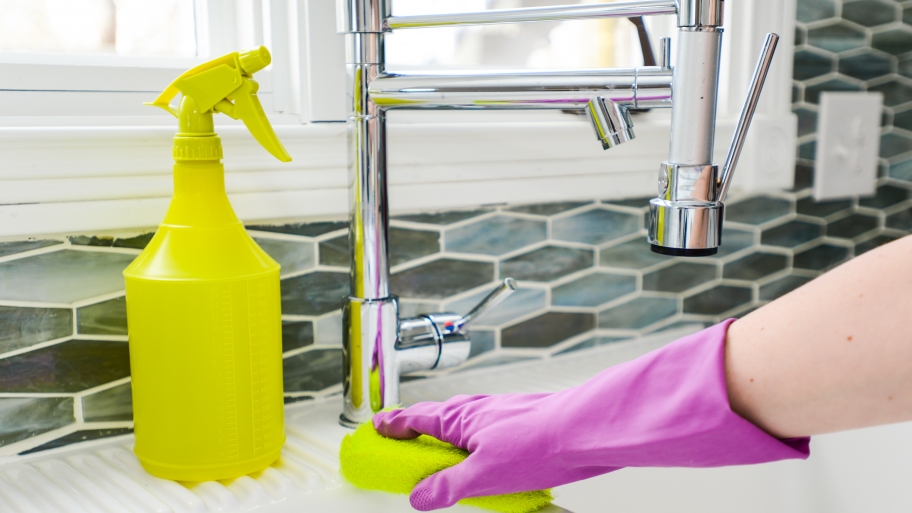house cleaning Hand scrubbing white sink with yellow sponge
